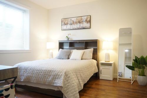 a bedroom with a large bed and a mirror at the blossom stay in Burnaby