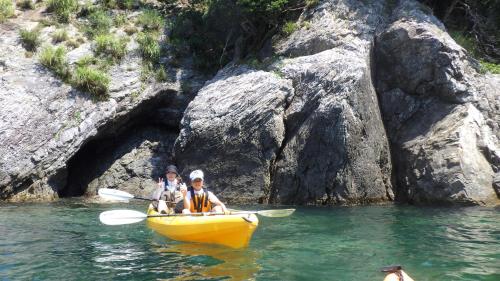 two people in a yellow boat in the water at 湖上館パムコ in Wakasa