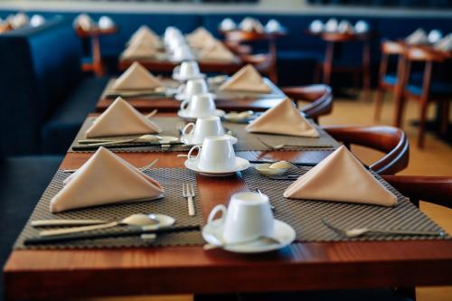 a long wooden table with napkins and dishes on it at Bella Vita Hotel in Long Hai