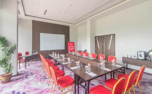 a meeting room with a long table and red chairs at Bigland Hotel & Convention Sentul in Bogor