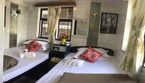 2 camas individuales en una habitación con ventanas en Skystar Hostel, en Hong Kong