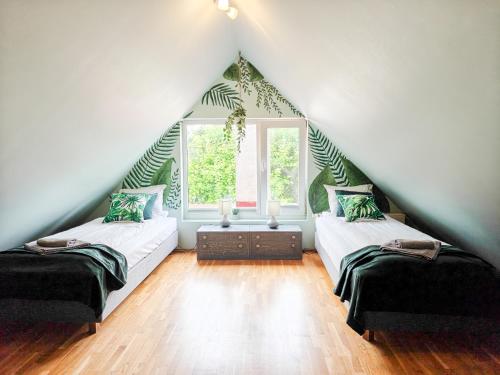 a attic room with two beds and a window at Esplanaadi Villa in Pärnu