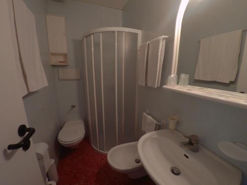 a white bathroom with a sink and a toilet at Hotel Ada in Milan