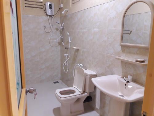 a bathroom with a shower and a toilet and a sink at Silent Bungalow in Udawalawe