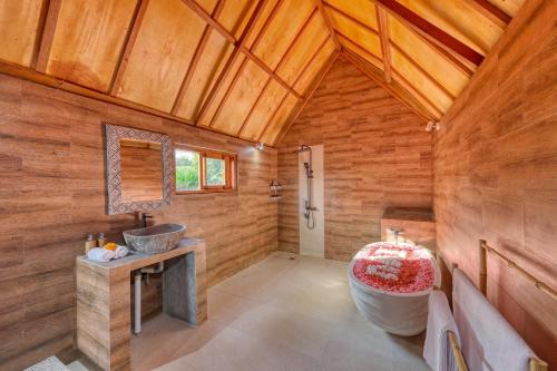 a bathroom with a large tub and a sink at Bunut Bungalow in Nusa Penida