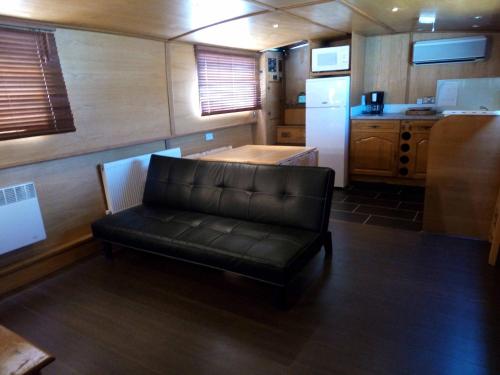 a living room with a couch in a kitchen at Péniche Poompui in Aigues-Mortes