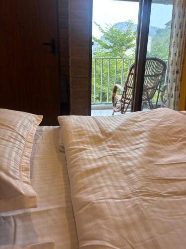 a bed in a bedroom with a view of a balcony at Prakruthi Hill View 3BHK Entire Villa in Nandi
