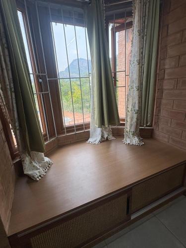 a window seat with a view of a mountain at Prakruthi Hill View 3BHK Entire Villa in Nandi
