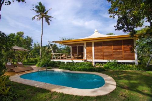 uma villa com uma piscina e uma casa em Donatela Resort and Sanctuary em Panglao