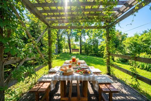 a picnic table in a pergola with food on it at Pivka Na Meji Resort in Pivka