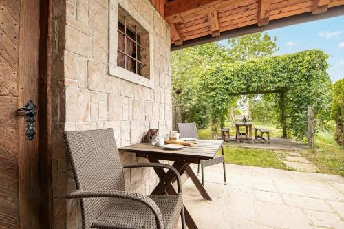 an outdoor patio with a table and chairs on a stone wall at Pivka Na Meji Resort in Pivka