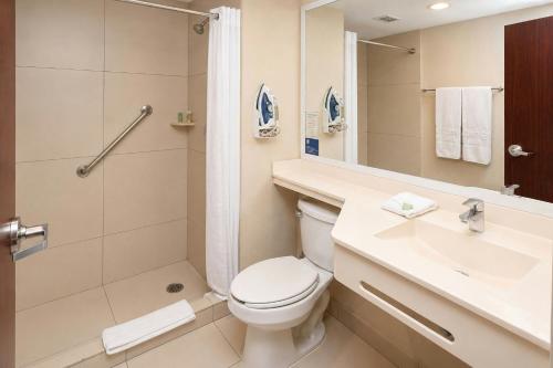 a bathroom with a toilet and a shower and a sink at City Express by Marriott Ciudad Obregon in Ciudad Obregón