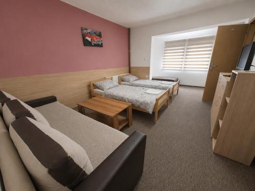 a hotel room with two beds and a couch at Hostel Imran Zenica in Zenica