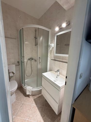 a bathroom with a shower and a sink and a toilet at Beach Rooms Split in Split