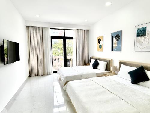 a hotel room with two beds and a television at Coconut Hotel in Phú Quốc