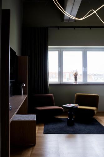 a living room with two chairs and a table at ALPAMI Boutique Glockenbach in Munich