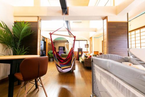 a room with a hammock hanging from the ceiling at コテージくつろぎ in Tsuru 