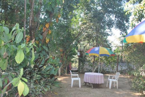 a table and chairs and an umbrella in a yard at Hilltop Lodge in Guwahati