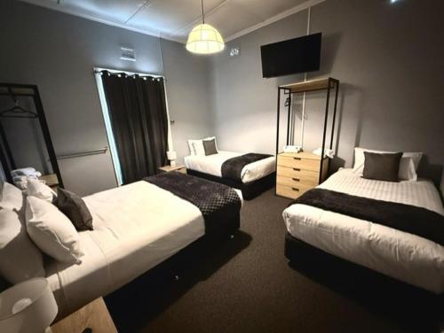 a hotel room with two beds and a television at Royal Hotel Tumut in Tumut