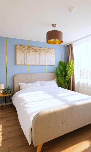 a large bed in a bedroom with a blue wall at Cofy Rentals - old town, quiet area, air-conditioning, free parking, 24-7 express check-in-out, close to green parks, everything you need for living in Pärnu