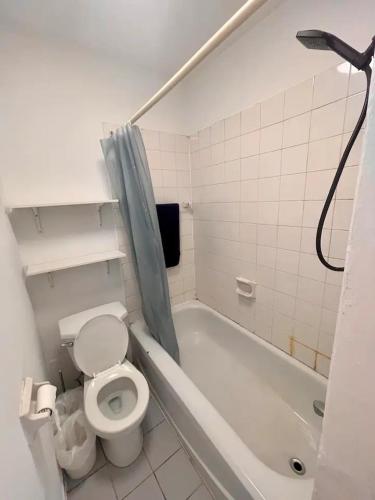 a bathroom with a toilet and a bath tub at Full Kitchen METRO DE LEGLISE Room B in Montreal