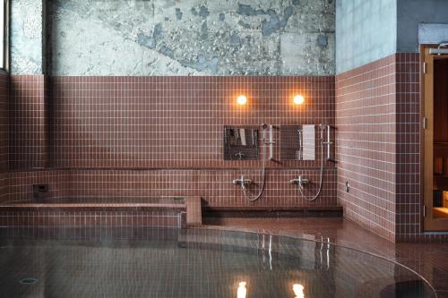 a bathroom with red tiled walls and a mirror at 島泊 島飯 島湯 in Tonosho