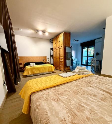 a bedroom with two beds and a yellow blanket on the floor at INCLUSIVeLOFT in Legnano