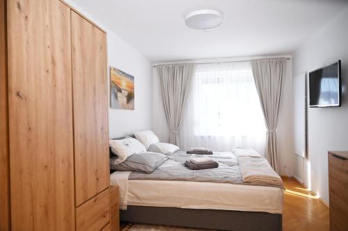 ein Schlafzimmer mit einem Bett und einem großen Fenster in der Unterkunft Apartment Sofia in Barnbach