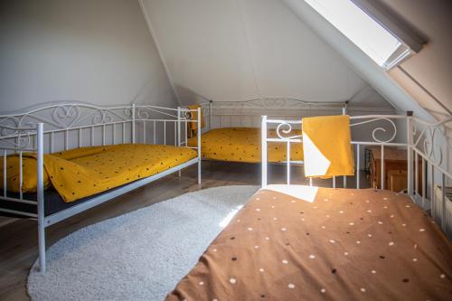 a room with two bunk beds in a attic at Vakantiehuis 'Oan de Feart' in De Valom