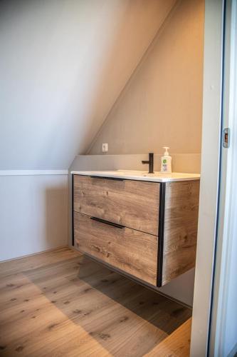 a bathroom with a sink in the middle of a attic at Vakantiehuis 'Oan de Feart' in De Valom