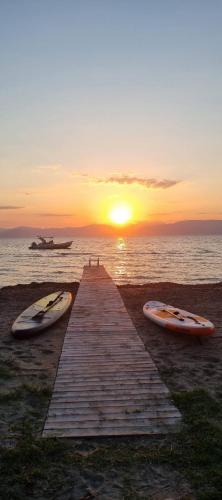 two surfboards are sitting on a dock with the sunset at Melador beachfront studios in Kavos