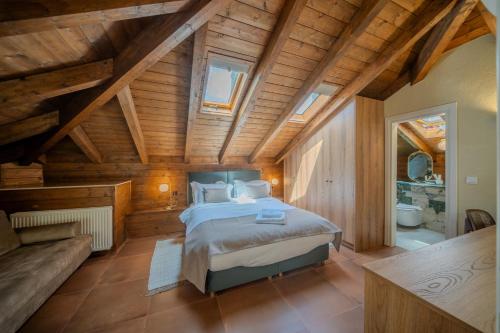 a bedroom with a bed in a room with wooden ceilings at Leon Suites Nemea in Neméa