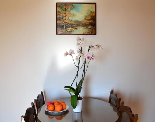 una mesa de comedor con un jarrón de flores y naranjas en Apartment Matea, en Petrovac na Moru