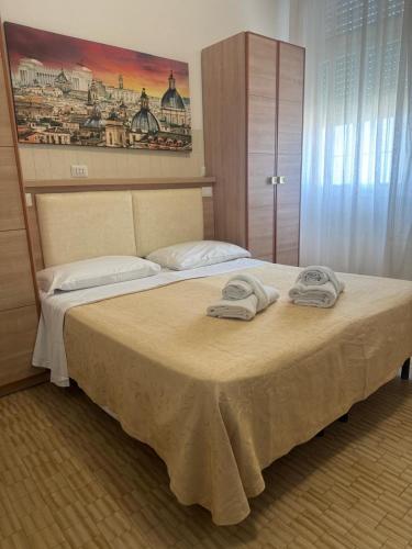 a bedroom with a bed with two towels on it at Campus Baia Serena in Bellaria-Igea Marina