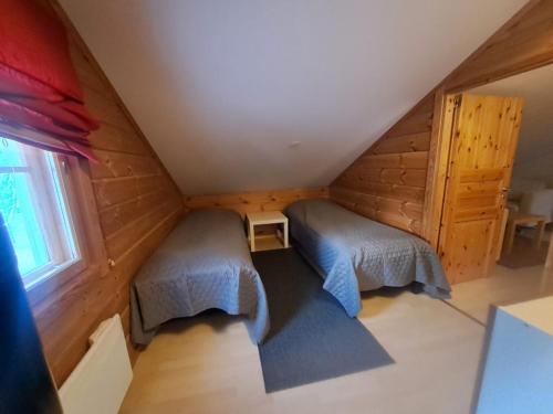 a attic room with two beds and a window at Aabro, Levi in Kittilä