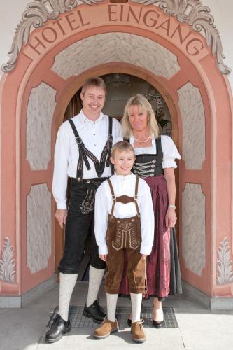 a man and a woman standing in front of an arch at Hotel Landhaus Feldmeier ***S in Oberammergau
