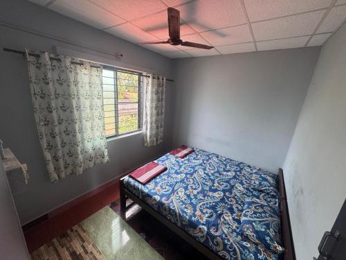 a bedroom with a bed and a ceiling fan at KENSON'S INN - Non AC - 2 Bedroom Apartment in Mangalore