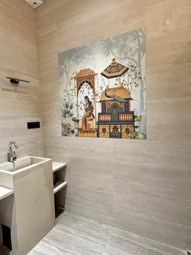 a bathroom with a sink and a painting on the wall at The Benjamins Pool Villa in Jodhpur