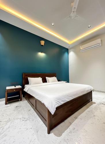 a bedroom with a large bed with a blue wall at The Benjamins Pool Villa in Jodhpur