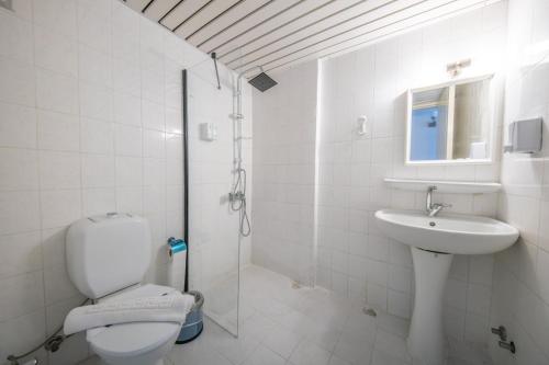 a white bathroom with a toilet and a sink at SUNMARİS CİTY HOTEl in Marmaris