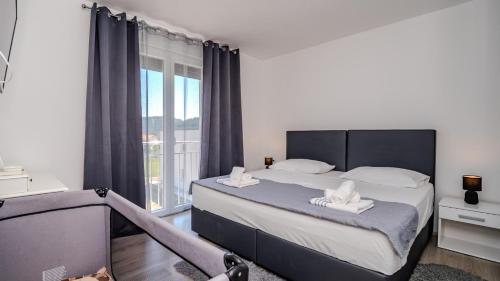 a bedroom with a bed and a large window at Villa Rab Paradise pool by Villas Guide in Lopar