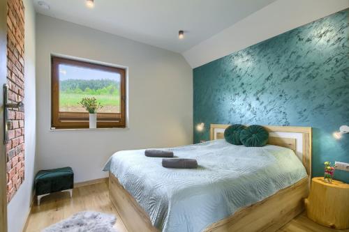 a bedroom with a large bed with a window at Wyborny Zakątek in Powrożnik