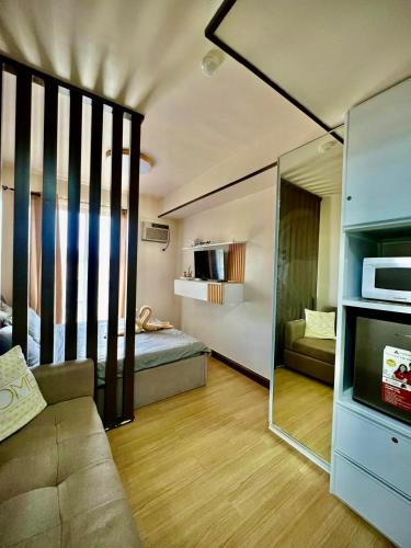 a living room with a couch and a mirror at Cozyluxe at Pine Suites Tagaytay in Kaybagal