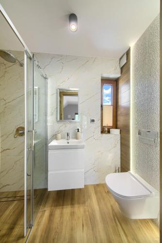 a bathroom with a white sink and a shower at Wyborny Zakątek in Powrożnik