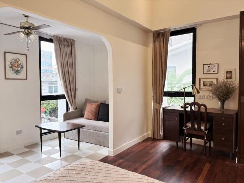a bedroom with a couch and a desk and window at Pennkiat House in Bangkok