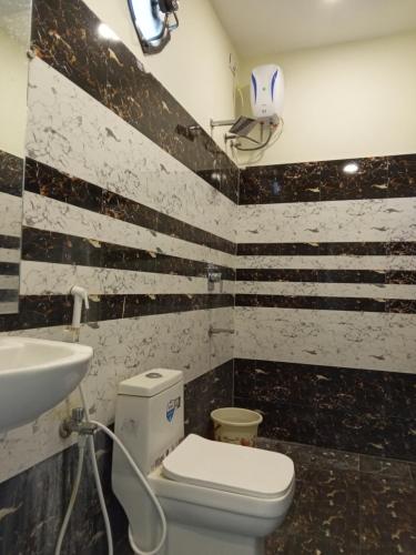 a bathroom with a toilet and a sink at Mega Grand Rooms in Narasaraopet