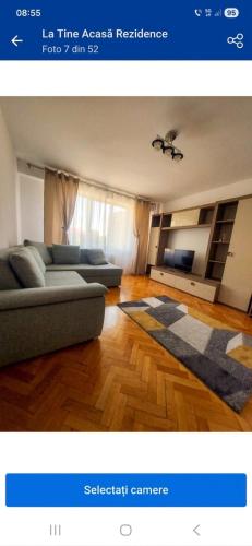 a living room with a couch and a television at La Tine Acasă Rezidence in Oradea