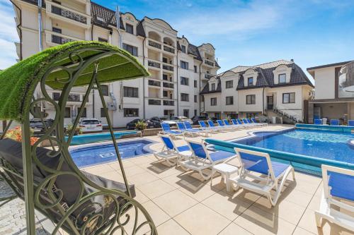 a swimming pool with lounge chairs and a hotel at MARION SPA Hotel in Bukovel