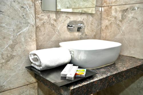 a bathroom with a sink and a towel on a counter at Hotel Shri Ram Residency in Belgaum