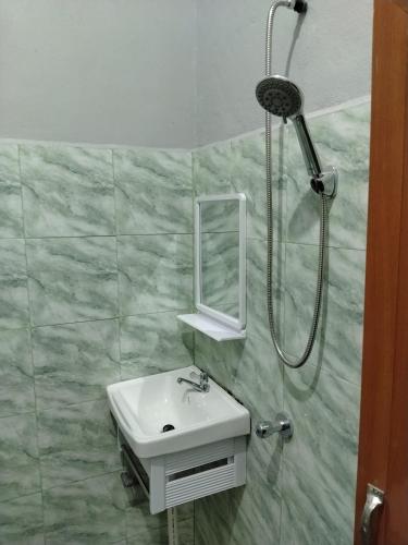 a bathroom with a sink and a shower at Roomstay Ust Omar in Tumpat